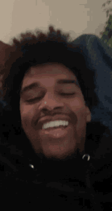 a close up of a man 's face with his eyes closed and a smile on his face .