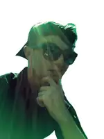 a man wearing sunglasses and a baseball cap looks at the camera