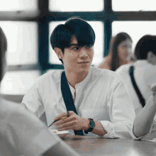 a man with a watch on his wrist sits at a table