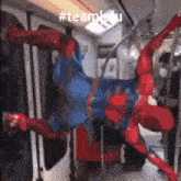 a picture of a spiderman hanging upside down on a subway train .