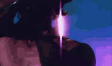 a close up of a person 's face with a purple light coming out of their eyes