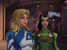 a woman in a blue and white suit is standing next to a woman in a green suit