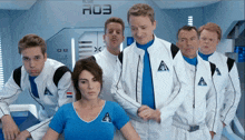 a group of people are standing in front of a sign that says a03