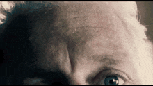 a close up of a man 's face with a beard and blue eyes