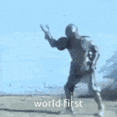 a man in armor is standing in the dirt with the words world first written on the bottom .