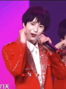 a man in a red jacket is holding a microphone