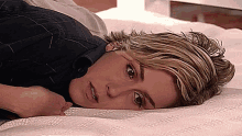 a woman laying on a bed with her eyes closed and her mouth open