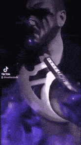 a man with a beard is holding a sword with a purple background