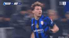 a soccer player wearing a blue and black striped jersey with the number 1 on it