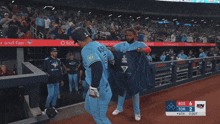 two blue jays baseball players are hugging each other in the dugout