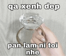 a person is holding a diamond ring in their hand