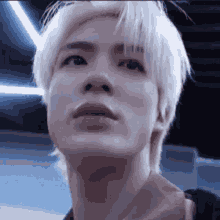 a close up of a young man 's face with white hair .
