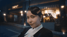 a woman in a suit stands in front of a building that says l' ent