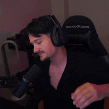 a man wearing headphones and a acer chair makes a heart shape with his hands