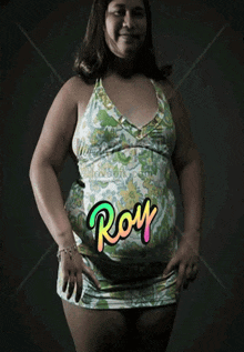 a woman in a floral dress with the name roy on her belly
