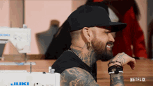 a man sitting in front of a sewing machine that says juki on it