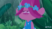 a troll with flowers in her hair is standing in the rain and says touche
