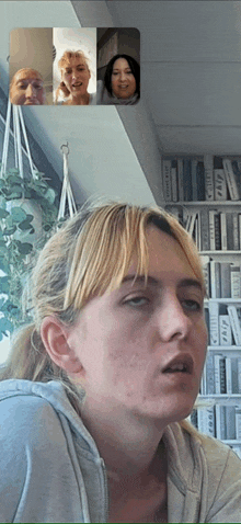 a group of people are on a video call and one of them is looking at her face