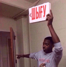 a man in a maryland shirt is holding up a sign