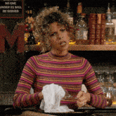 a woman wipes her mouth with a napkin in front of a sign that says " no one under 21 will be served "