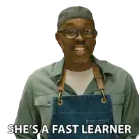 a man wearing glasses and an apron says " she 's a fast learner "