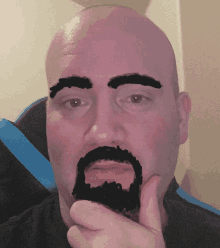 a bald man with a beard has his eyebrows drawn on his face