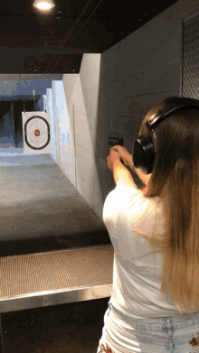 a woman is aiming a gun at a target