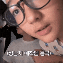 a close up of a person 's face with glasses and korean writing on it
