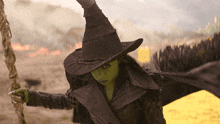 a woman in a witch costume holds a rope