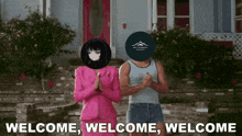 a man and a woman are standing in front of a house with the words welcome welcome welcome