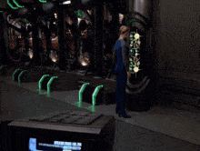 a woman in a blue jumpsuit is standing in front of a screen that says ' richard brooke ' on it