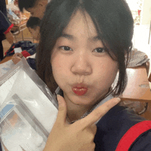 a girl making a funny face while holding a plastic bag