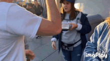 a woman wearing a shirt that says ' disneyland ' holds a bottle of water