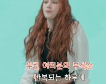 a woman with red hair stands in front of a blue background with chinese writing