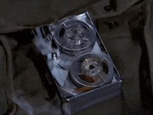 a close up of a tape recorder with two reels of tape in a box .