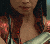a close up of a woman 's face with a sword in her hands