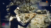 a man is playing a trumpet in front of trees and a sign that says ' a ' on it
