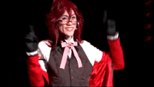 a woman with red hair and glasses is wearing a red vest