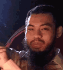a man with a beard is making a funny face in front of a car