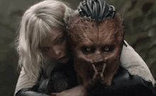 a woman is hugging a monster with a dreadlock on its head