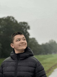 a boy wearing a black jacket with a hood