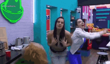 a couple of women are standing next to each other in a kitchen .