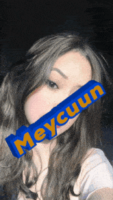 a woman with a blue block that says meycuun on her face