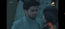 a man and a woman are looking at each other with a star life logo in the corner