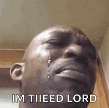 a man is crying with a tear coming out of his eye and the words im tiied lord written below him .