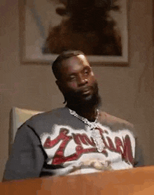 a man with a beard is sitting at a table .