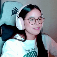 a girl wearing glasses and headphones is wearing a creepy stuff shirt