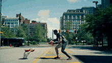 a man playing basketball with a dog on a street corner