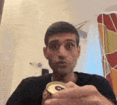a man in a black shirt is holding a can of something