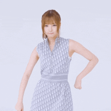 a woman in a sleeveless dior dress flexes her muscles